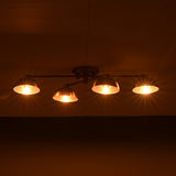 Low-profile handmade brass chandelier with four illuminated dome shades, casting golden lighting on the ceiling.