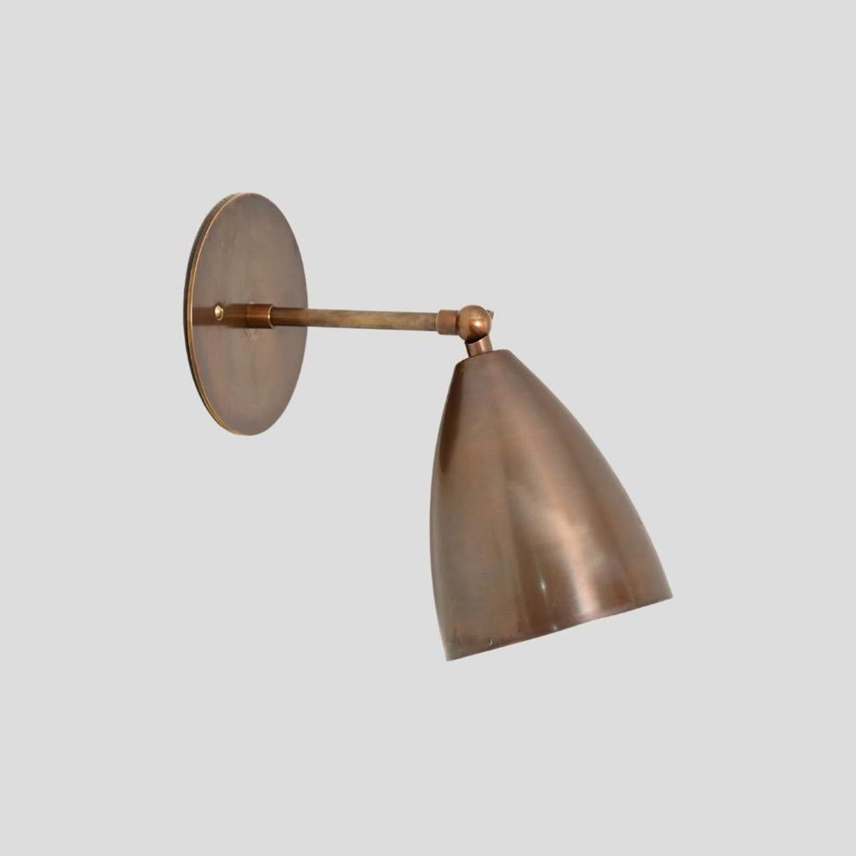 Solid brass wall sconce with adjustable arm and cone shade – handcrafted lighting for modern interiors