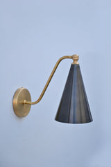 Sleek side profile of brass and blackened cone wall sconce, handcrafted with a refined matte finish.