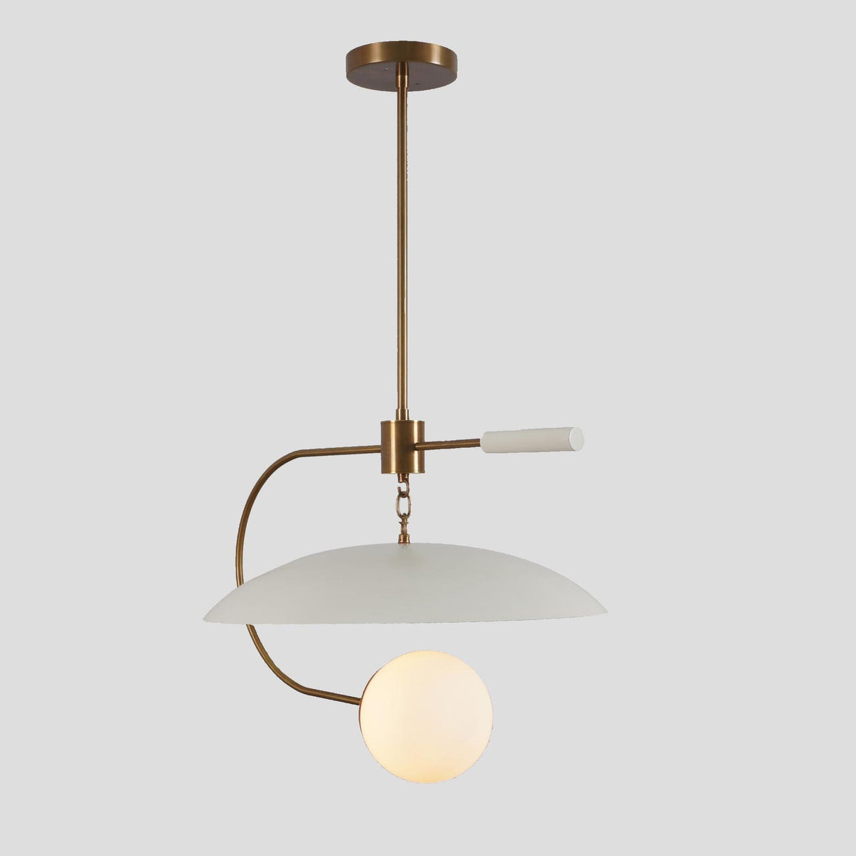 Minimalist brass and white pendant light with sleek linear structure and dome shade, perfect for dining rooms or design-forward spaces.