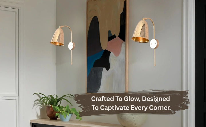 Pair of brass bell wall sconces mounted in a modern hallway interior beside contemporary artwork