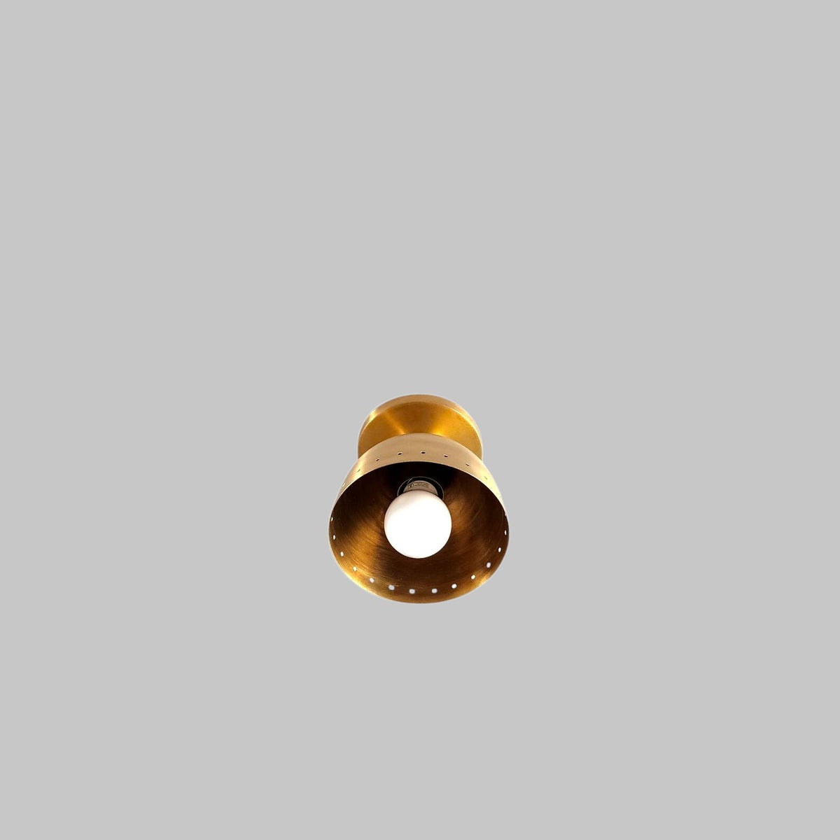 Bottom view of brushed brass bowl ceiling light showing E26 bulb and precision-crafted perforated edge design