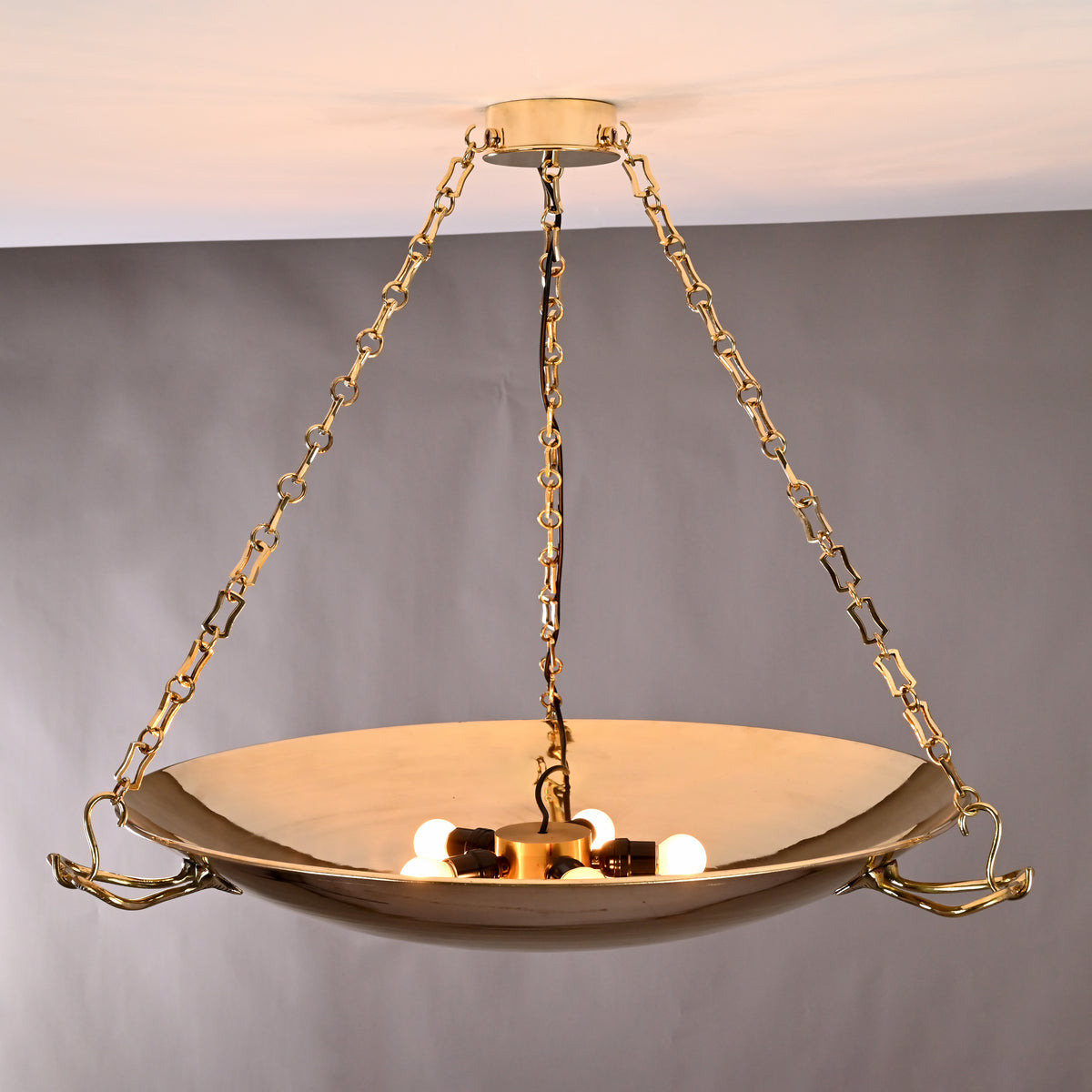 Close-up of brass bowl chandelier showing 5-light configuration and polished reflective surface