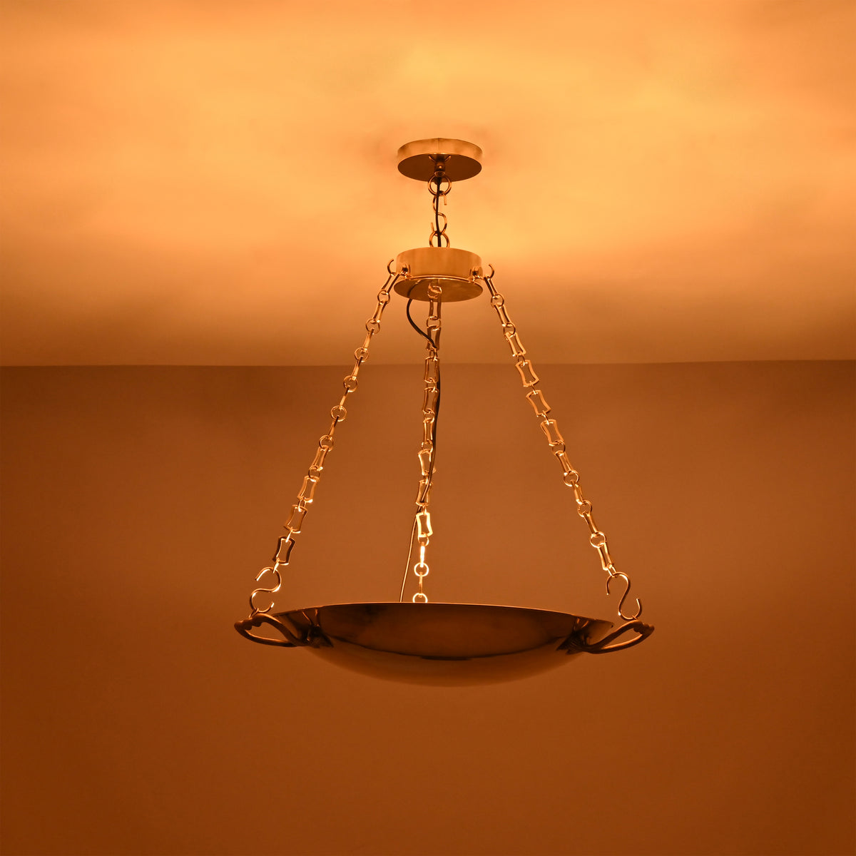 Brass bowl chandelier in an elegant living room creating warm ambient ceiling light and a refined classic interior look