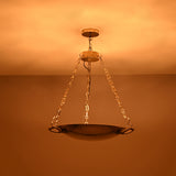 Brass bowl chandelier in an elegant living room creating warm ambient ceiling light and a refined classic interior look