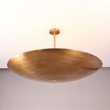 Handmade brass bowl pendant light with a smooth disc shape, modern solid brass ceiling fixture.