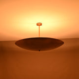 Warm night view of brass bowl pendant light casting soft ambient uplighting onto the ceiling.