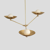 Modern brass pendant chandelier featuring three round frosted globes cradled in elegant bowl-shaped brass shades, handcrafted ceiling light.