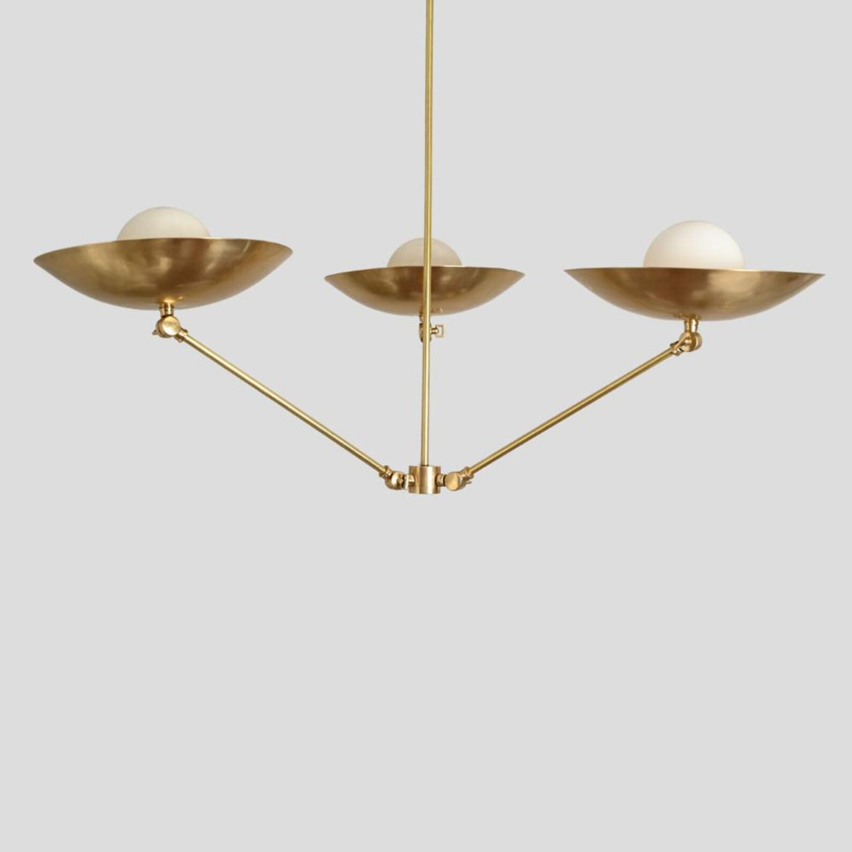 Contemporary brass chandelier with three bowl shades and frosted bulbs, handmade lighting fixture blending modern and industrial style.
