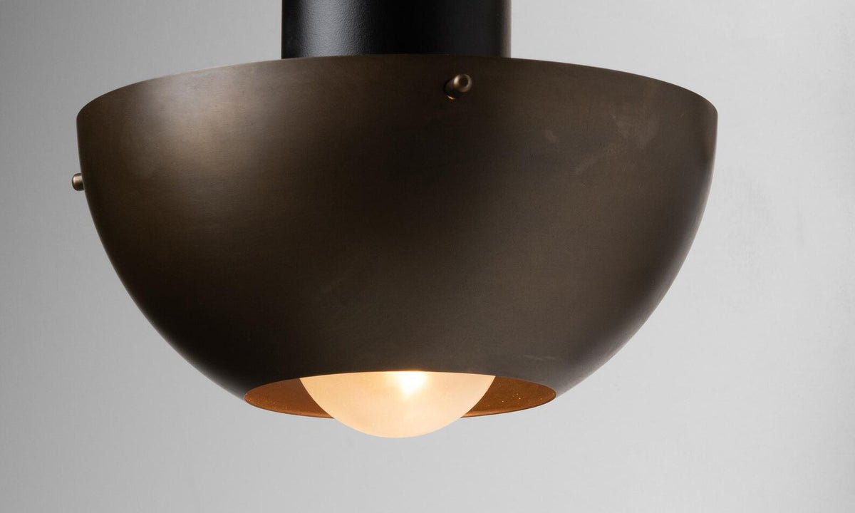 Bottom view of brass bowl wall lamp highlighting warm diffused light and smooth curved shade design.