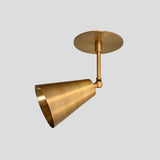Angled view of brass ceiling light with adjustable cone shade in minimalist design