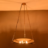 Night view of brass bowl chandelier showing soft uplighting and chain-supported design