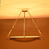 Chain-hung solid brass chandelier with sculpted handles and polished finish, reflecting classic design