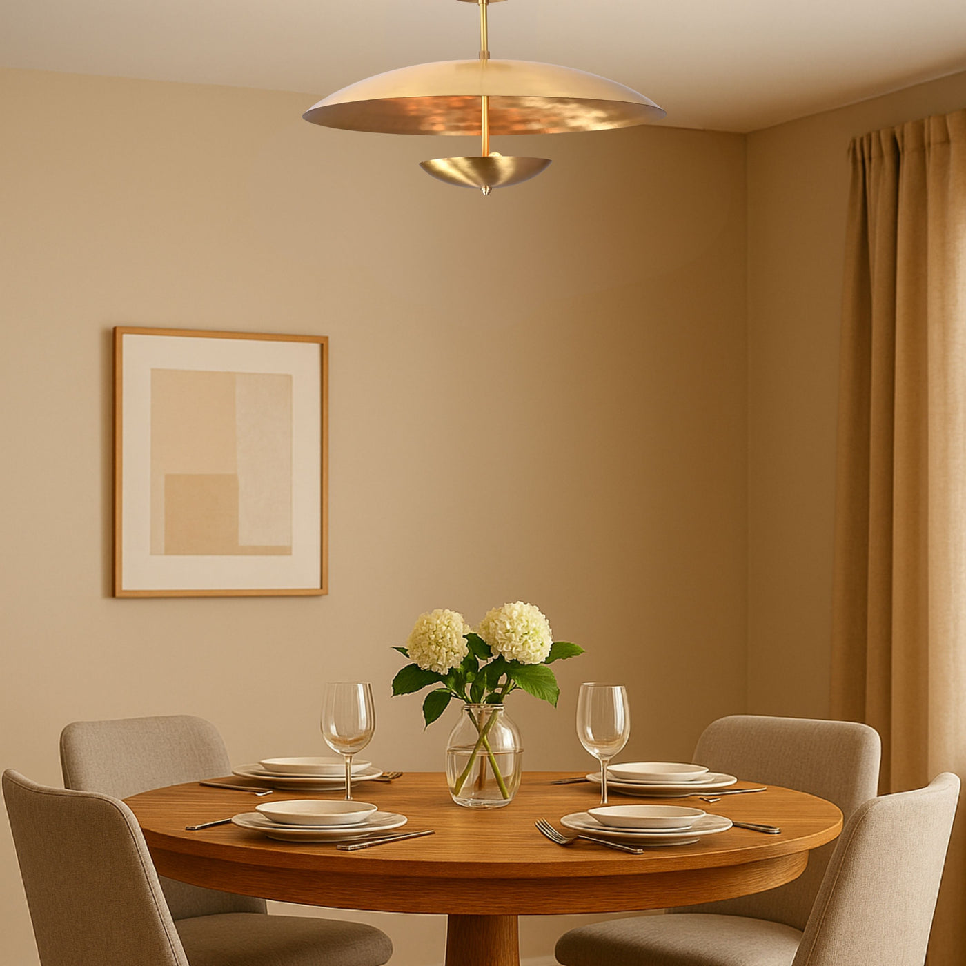 Modern brass disc chandelier above round dining table in warm-toned room, providing ambient lighting for contemporary interiors
