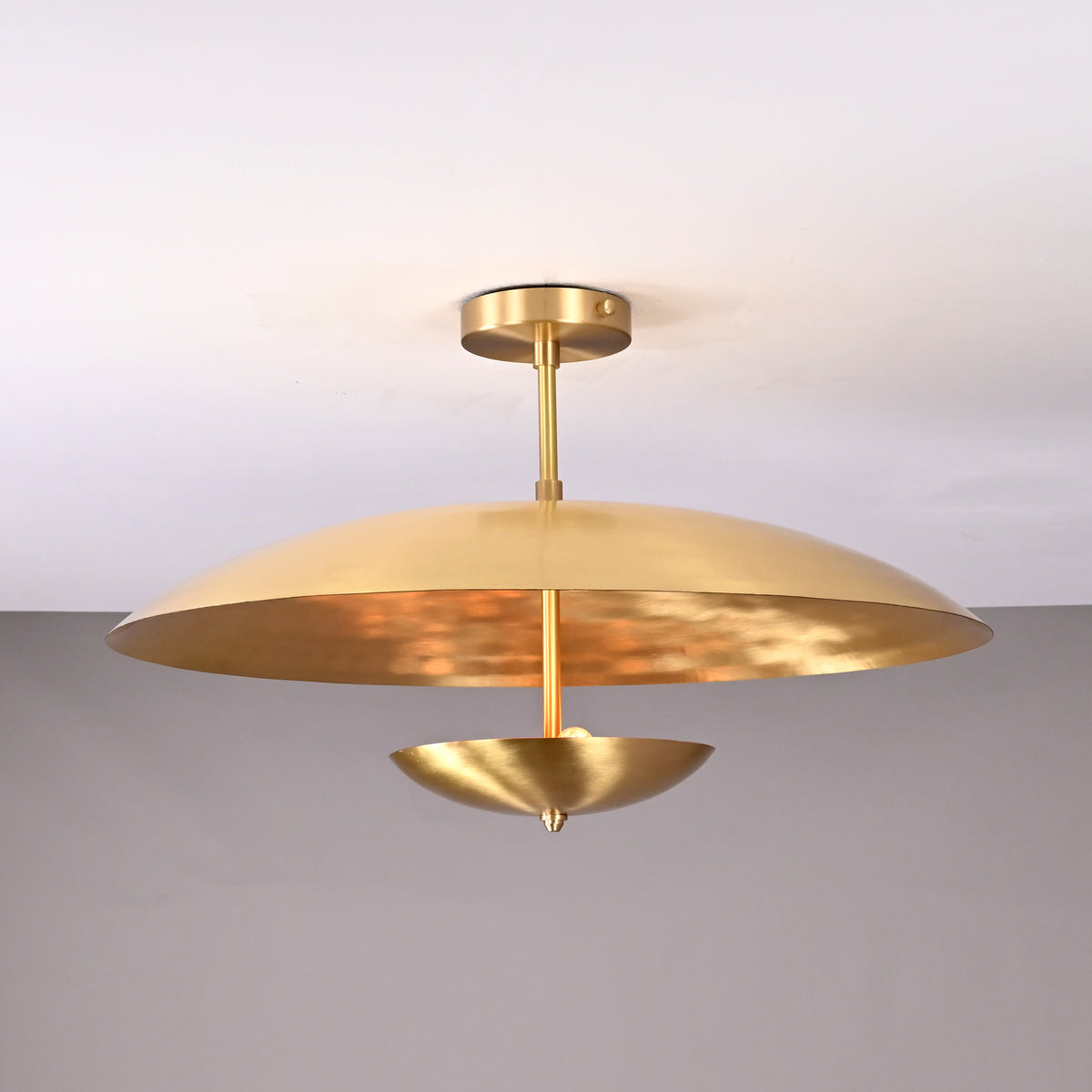 Front view of minimalist gold brass chandelier with disc design and cone-shaped lower bowl, ideal for dining or lounge areas