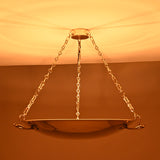 Full view of lit brass bowl chandelier spreading ambient light in classic interiors