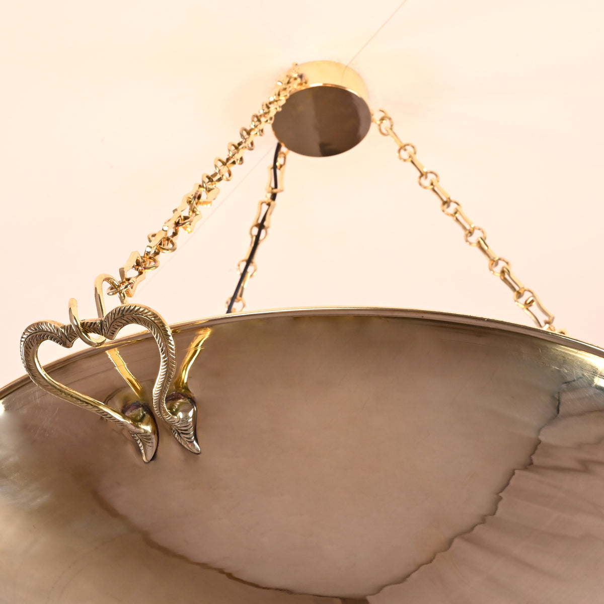 Suspended brass chandelier glowing against a ceiling, ideal for luxury interiors