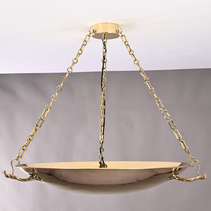 Glowing brass bowl chandelier with wide silhouette, radiating warm ambient light in vintage style