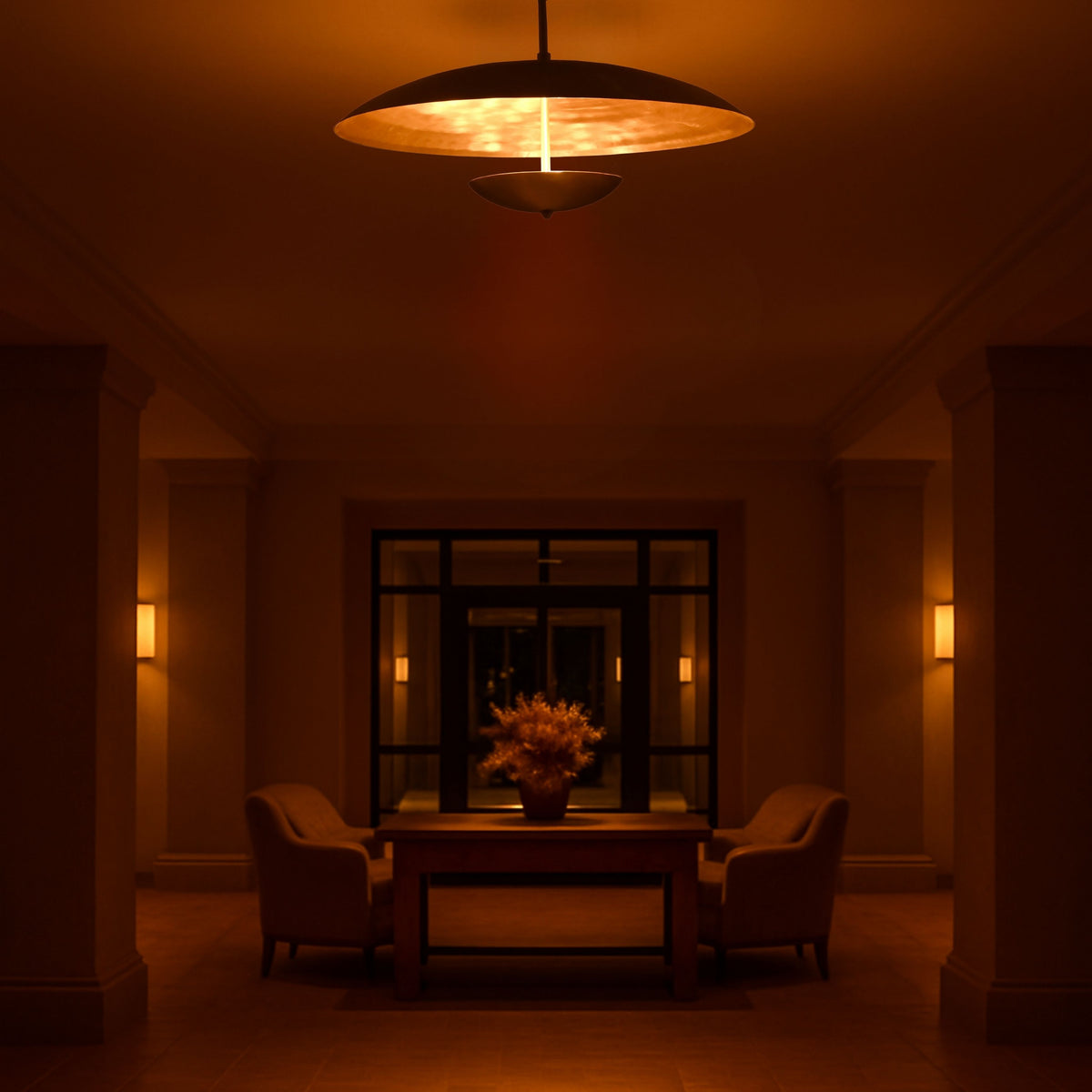 Elegant brass chandelier illuminating a hotel or foyer setting with warm diffused glow, perfect for lounges and entryways