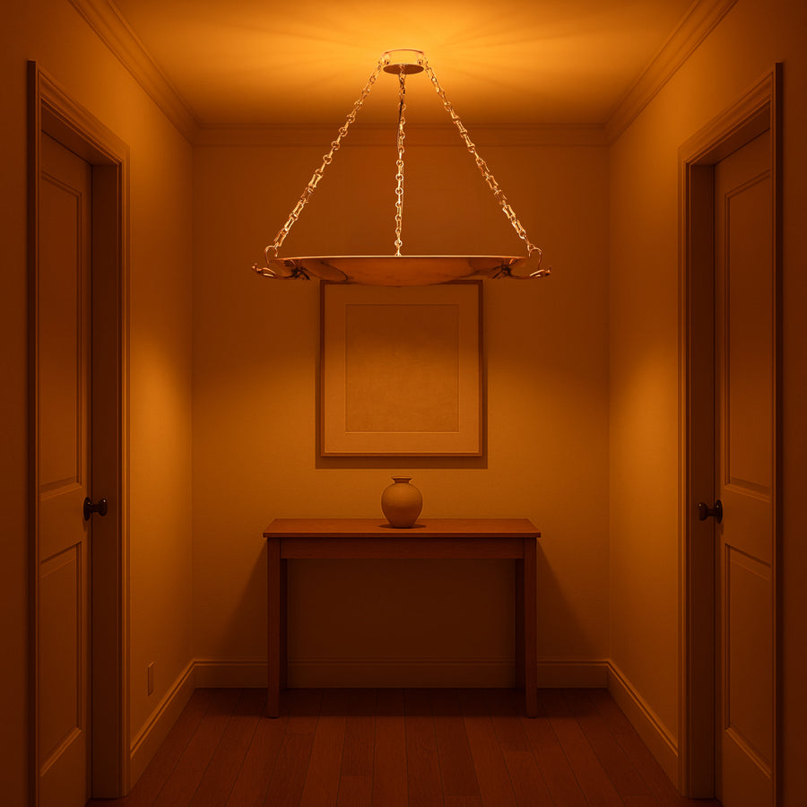 Brass bowl chandelier casting ambient glow in elegant hallway, suspended by golden chains
