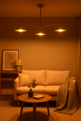 Warm ambient lighting from brushed brass chandelier with cone shades, styled in a cozy modern living room with soft neutral furnishings