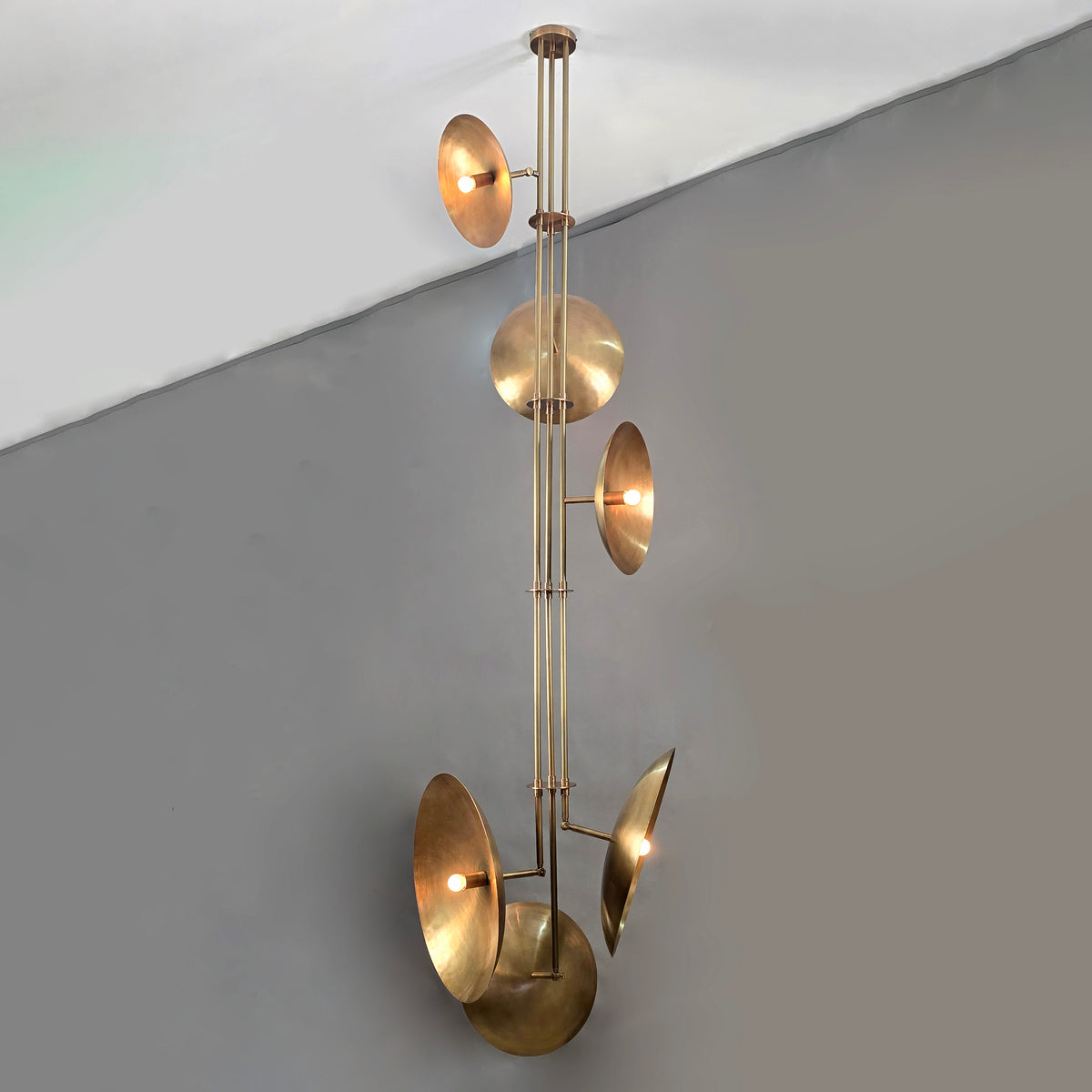 Brass disc chandelier in living space with fireplace, luxury light