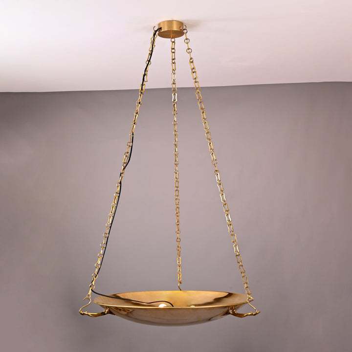 Side angle view of brass bowl chandelier suspended with four chain links and decorative handles