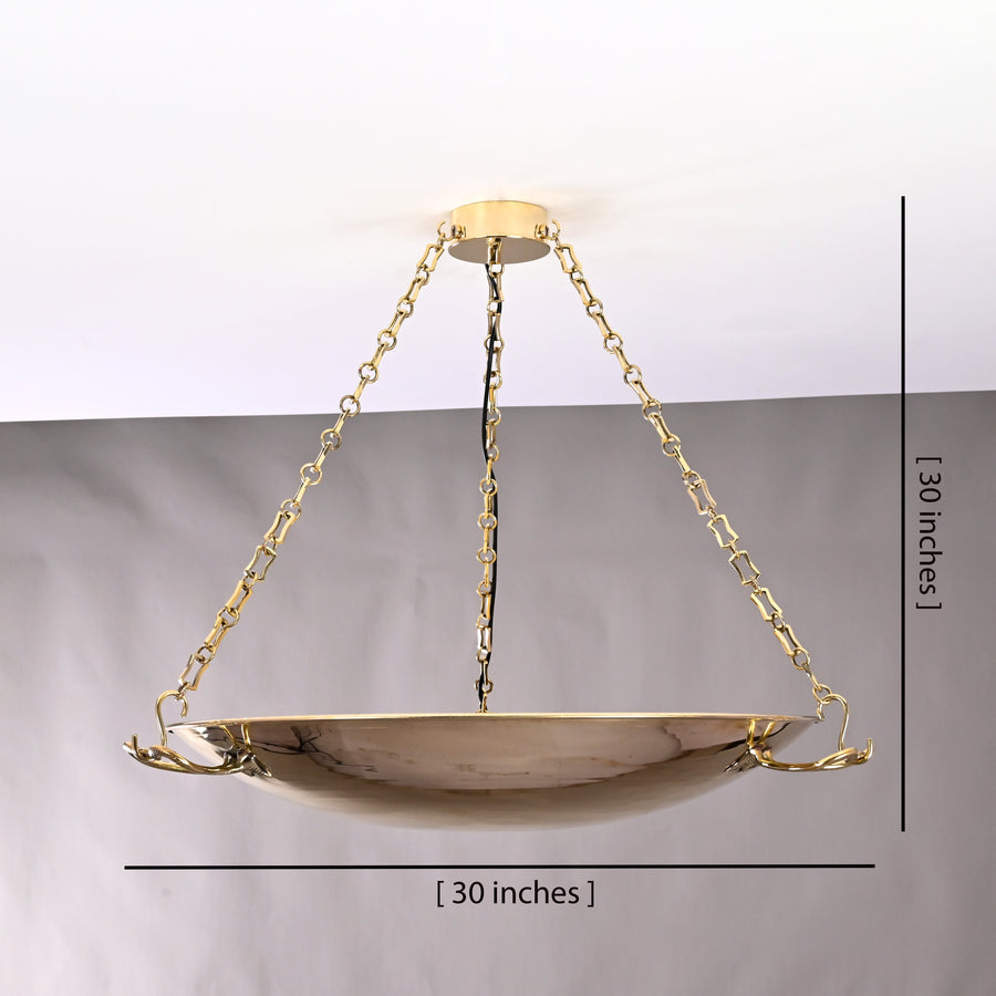 Brass bowl chandelier casting ambient glow in elegant hallway, suspended by golden chains