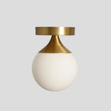 Modern flush mount ceiling light featuring brushed brass cone and round opal glass shade – handmade by Brass Leaf Studio