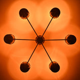 Ceiling light pattern created by perforated brass cone shades casting warm decorative glow in a handcrafted chandelier.
