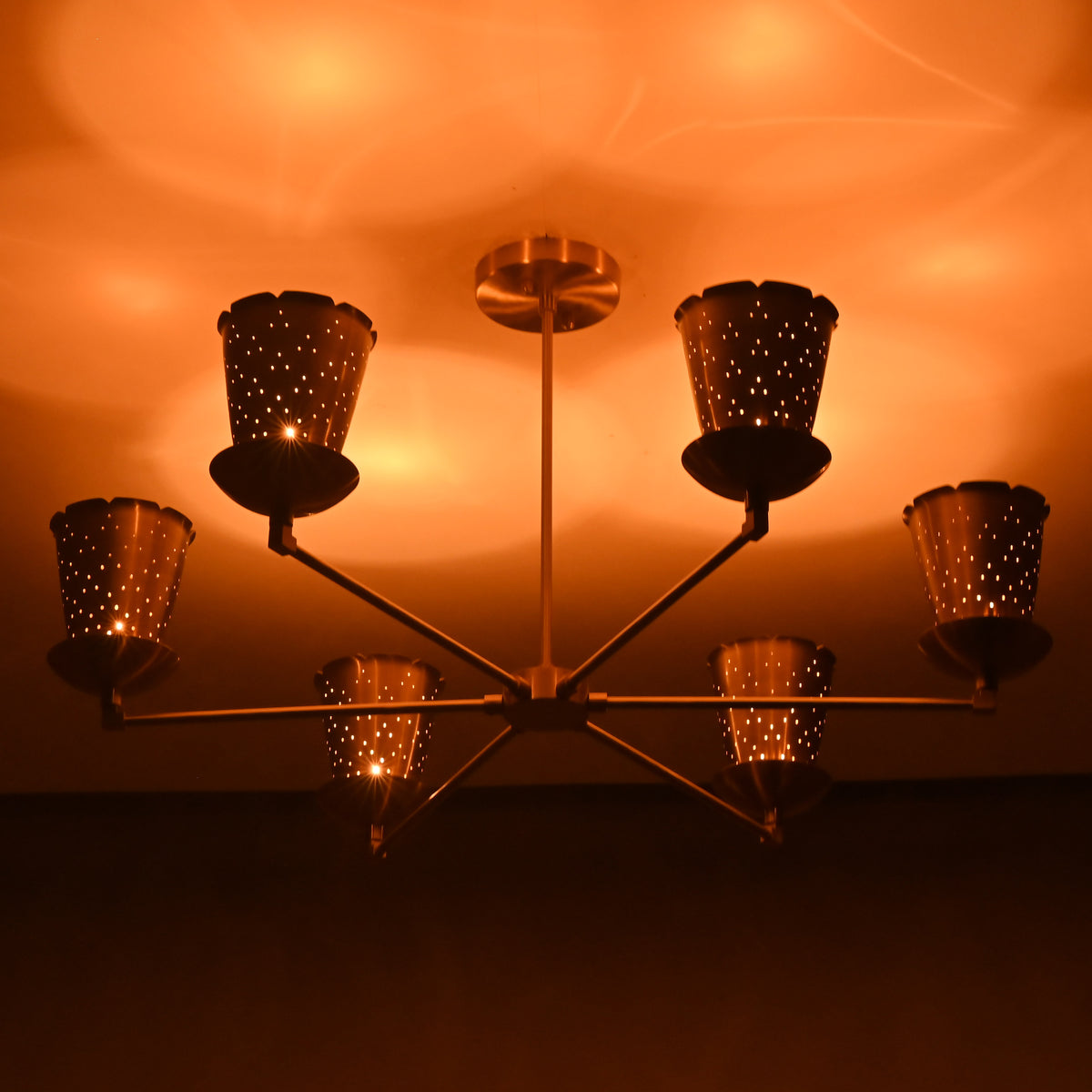 Close-up of perforated brass cone shade showing intricate light diffusion and handcrafted detailing.
