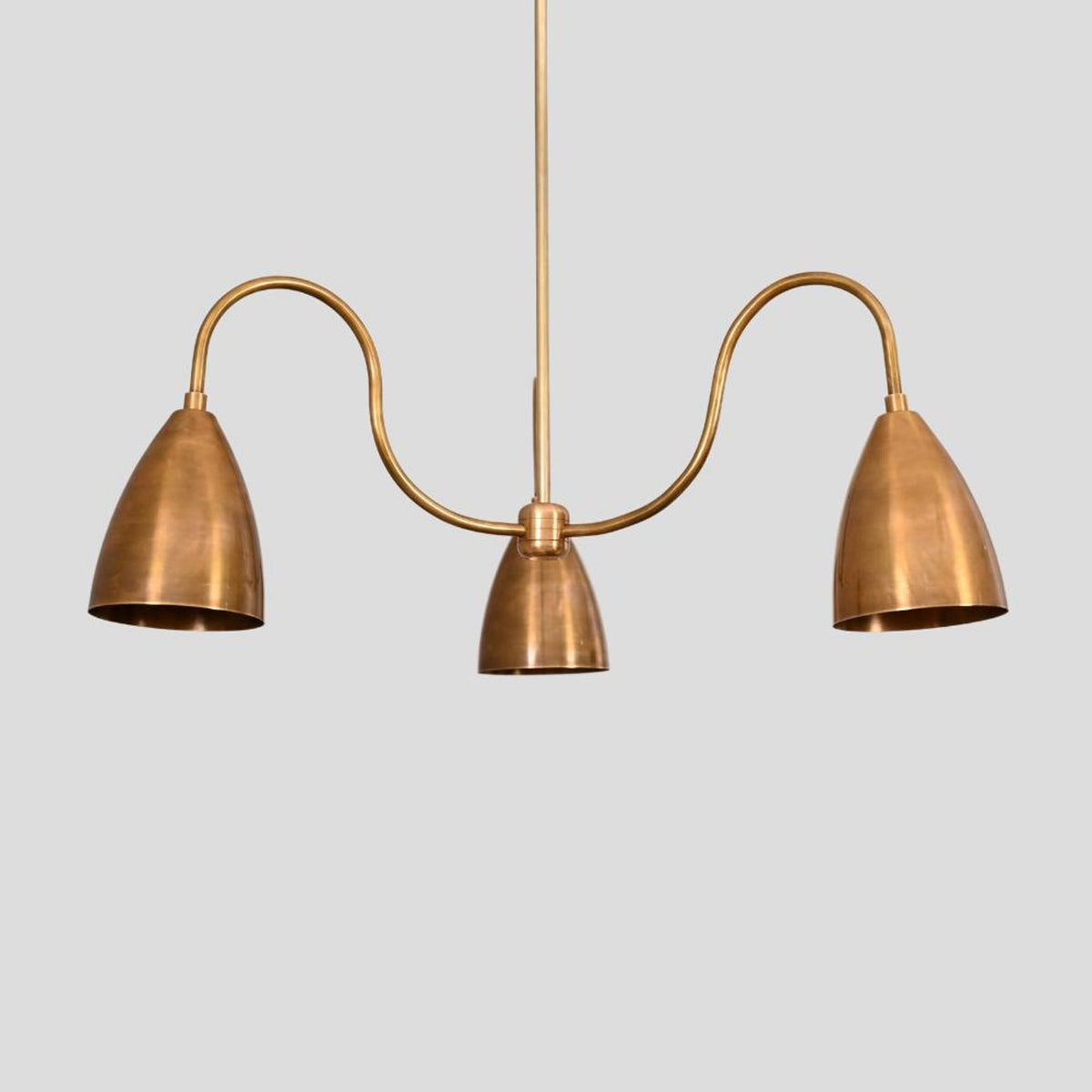 Straight view of brass 3-light chandelier with cone shades and minimalist industrial design, crafted by Brass Leaf Studio.