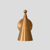 Brass wall sconce with cone-shaped shade, front view showcasing minimalist industrial handmade design.