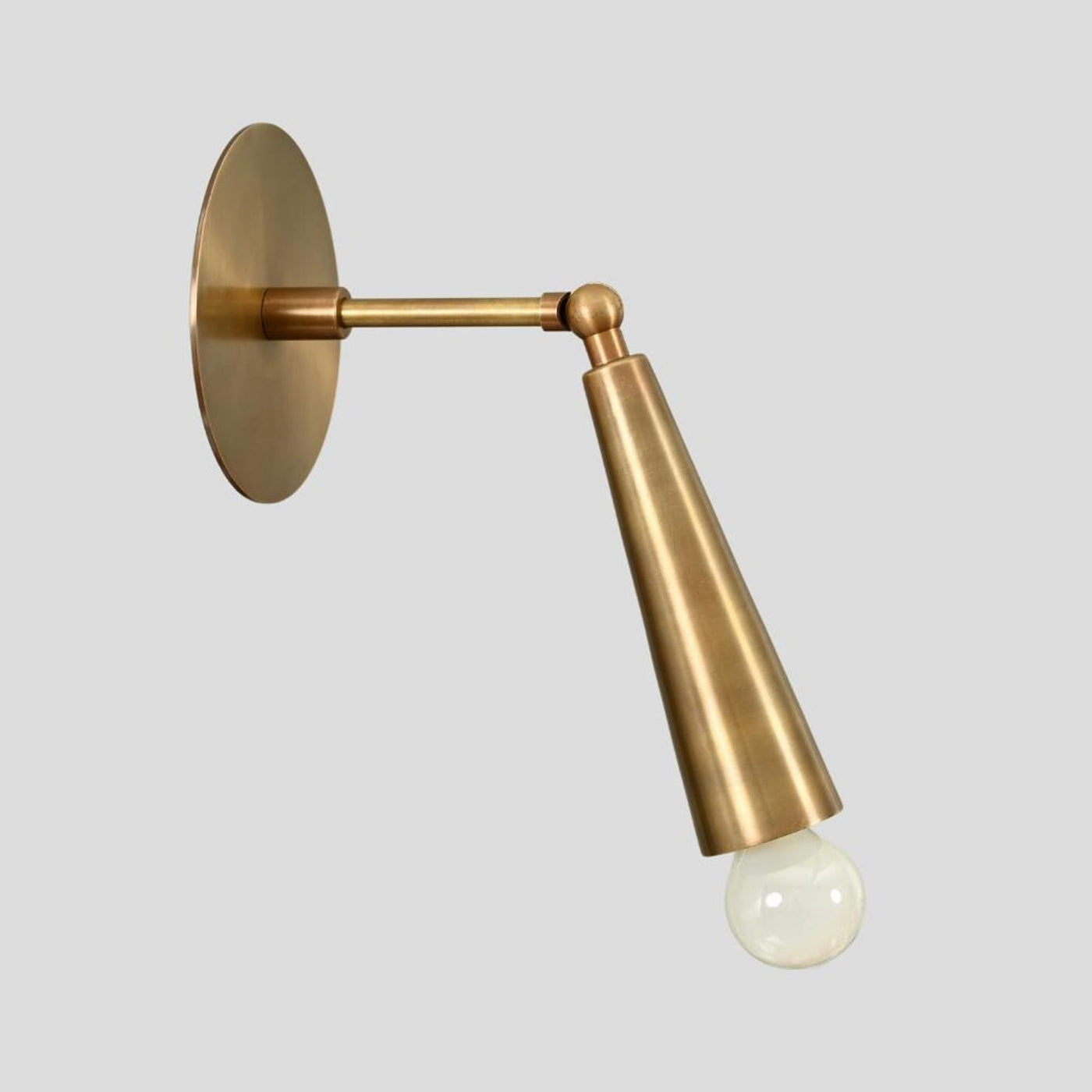 Brass cone wall sconce with exposed bulb design, handmade minimalist industrial lighting, side angle view.