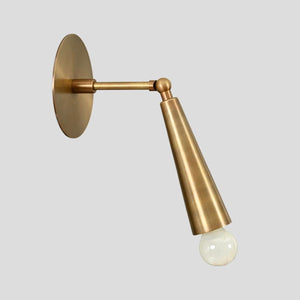 Brass cone wall sconce with exposed bulb design, handmade minimalist industrial lighting, side angle view.