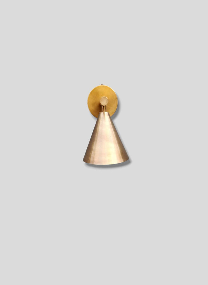 Front view of handcrafted brass cone wall sconce with smooth brushed finish and minimalist design by Brass Leaf Studio.