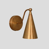 Handmade brass wall sconce with cone shade, minimalist industrial design by Brass Leaf Studio, side angle view.