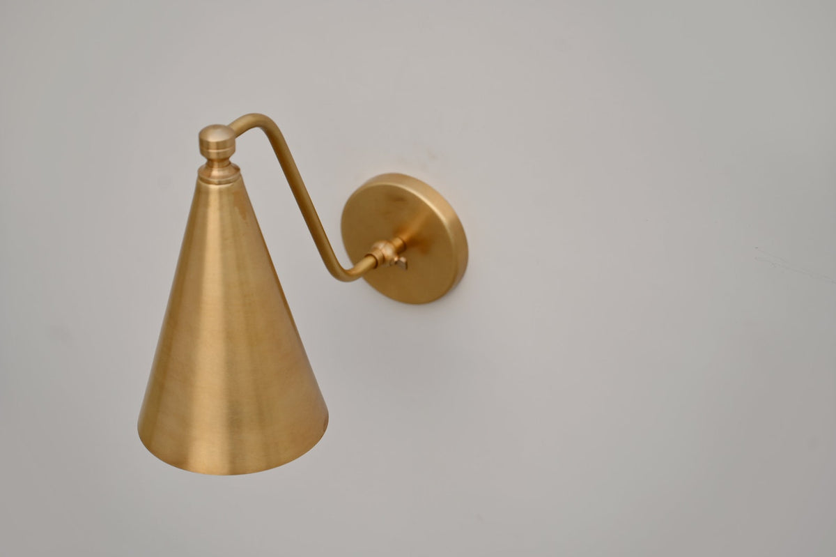 Top view of brass cone wall sconce with smooth brushed finish and elegant curved arm, handcrafted by Brass Leaf Studio.