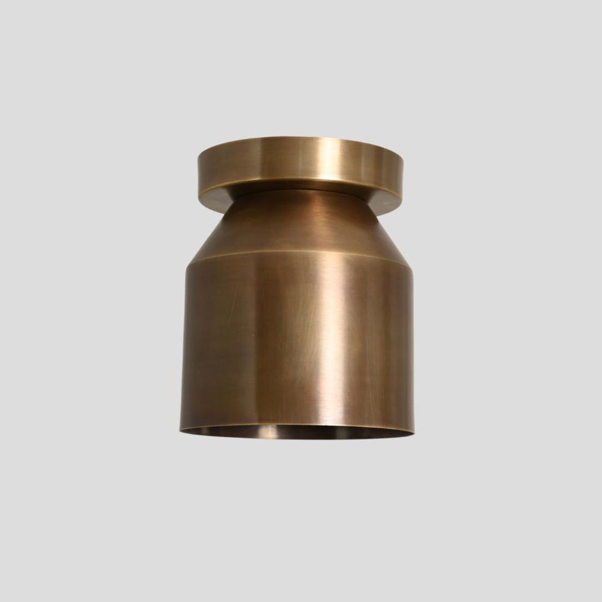 Front view of handcrafted brass cylinder ceiling light with smooth minimalist profile