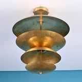 Low angle view of handcrafted brass disc ceiling light highlighting layered bowls and soft indirect illumination.