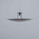 Side profile of modern brass disc flush mount ceiling light highlighting slim proportions and solid brass construction.