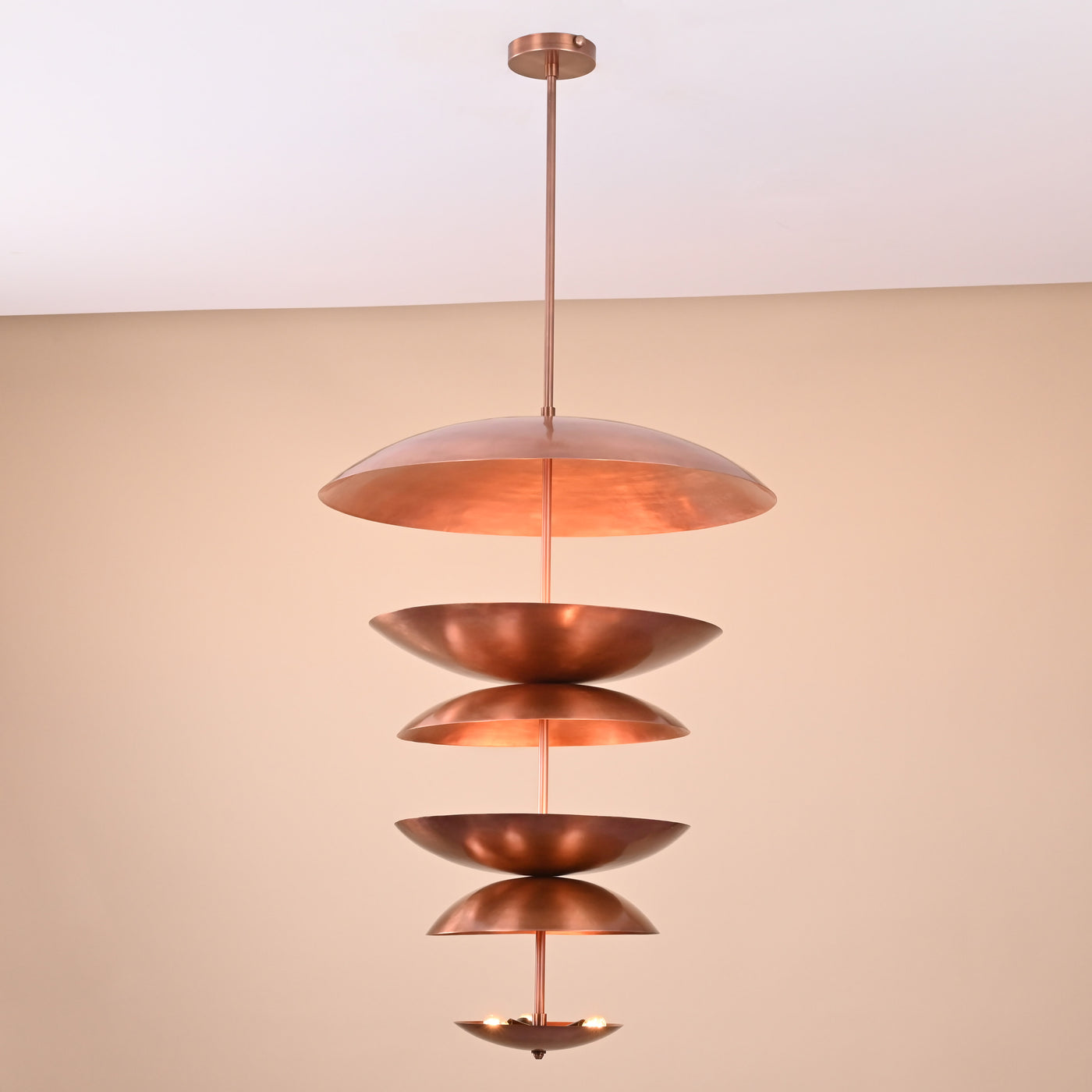Handmade 9-light brass disc chandelier featuring cascading dome layers in brushed copper finish against beige background