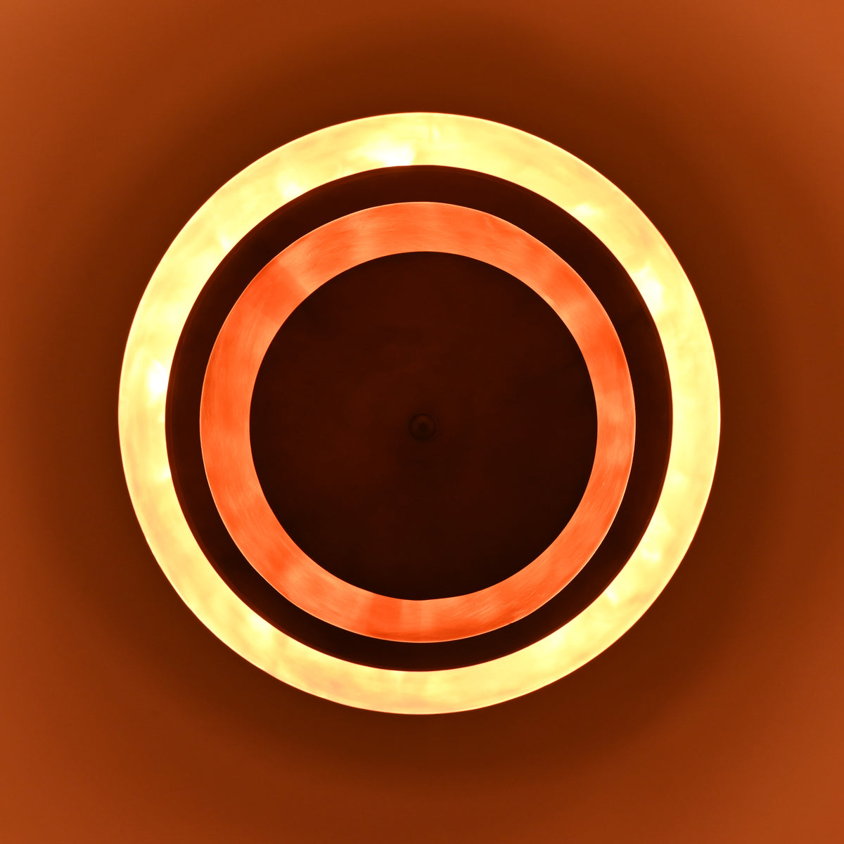 Glowing brass chandelier emitting layered indirect lighting with copper tones and soft ambient radiance