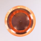 Illuminated top view of 9-light brass chandelier showing warm ambient glow with concentric circular reflection pattern