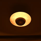 Underside view of brass pendant light showing glowing circular illumination and smooth brass finish
