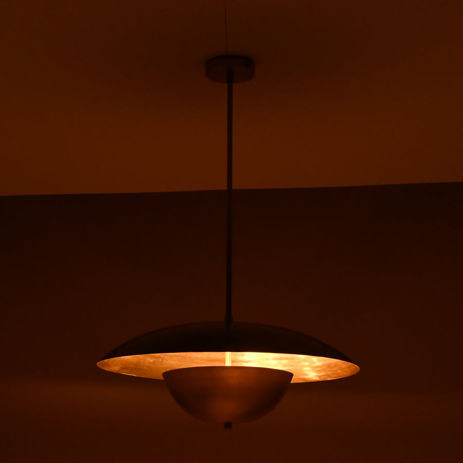 Handmade brass disc pendant light with dual dome design in raw and brushed brass finish against a neutral background