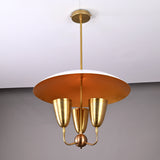 Side view of brass dome pendant light with white exterior dome and gold inner finish, featuring three sculpted brass light cups.