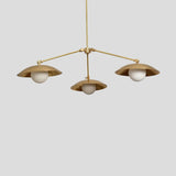Modern brass chandelier featuring three frosted globe lights set in dome-shaped brass shades, handcrafted pendant for dining or living spaces.