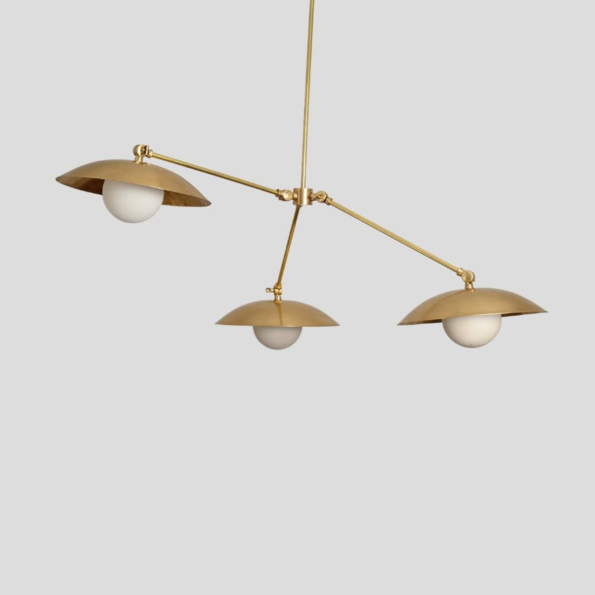 Side view of handmade brass chandelier with dome shades and frosted bulbs, minimalist and industrial pendant design.