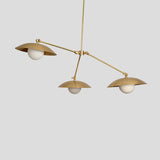 Side view of handmade brass chandelier with dome shades and frosted bulbs, minimalist and industrial pendant design.